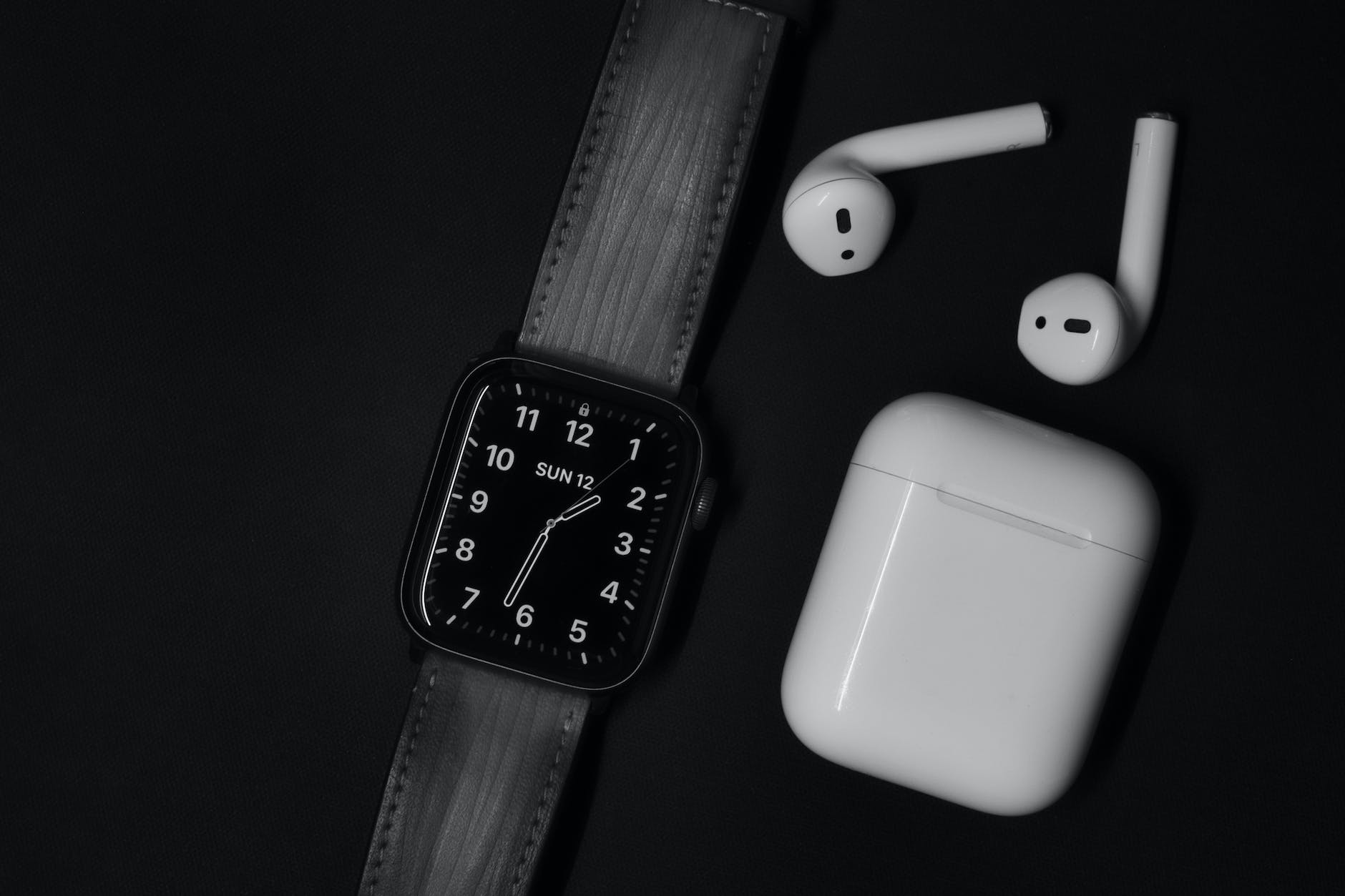 apple watch and air pods on black surface